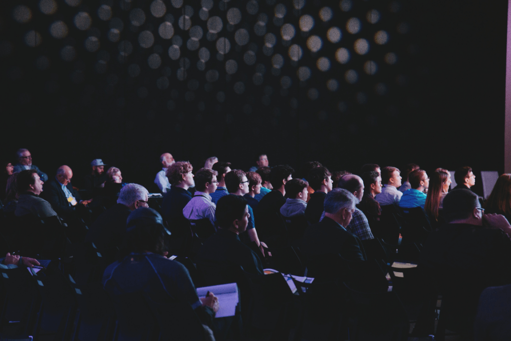 Publikum im abgedunkelten Saal bei einem Kongress in Stuttgart